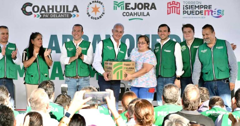 Alcalde entregando una caja de despensa a una mujer, rodeados de vecinos en Torreón.