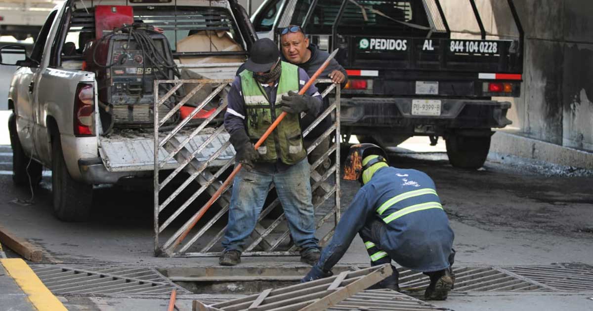 Trabajadores reparando rejillas pluviales en Saltillo.