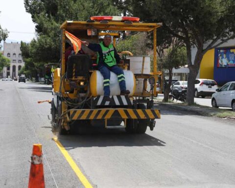Trabajador en una máquina delimitando un carril en Avenida Universidad de Saltillo.
