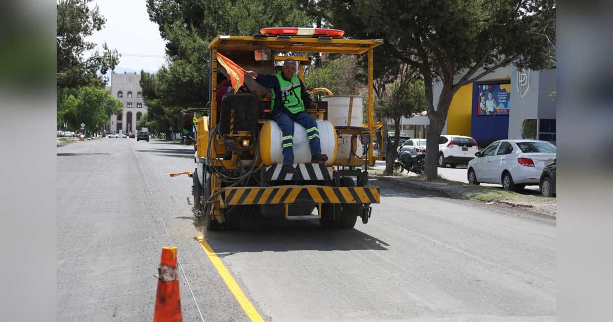 Trabajador en una máquina delimitando un carril en Avenida Universidad de Saltillo.