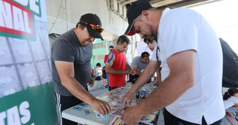 Grupo de hombres con sus álbumes en el intercambio de estampas.