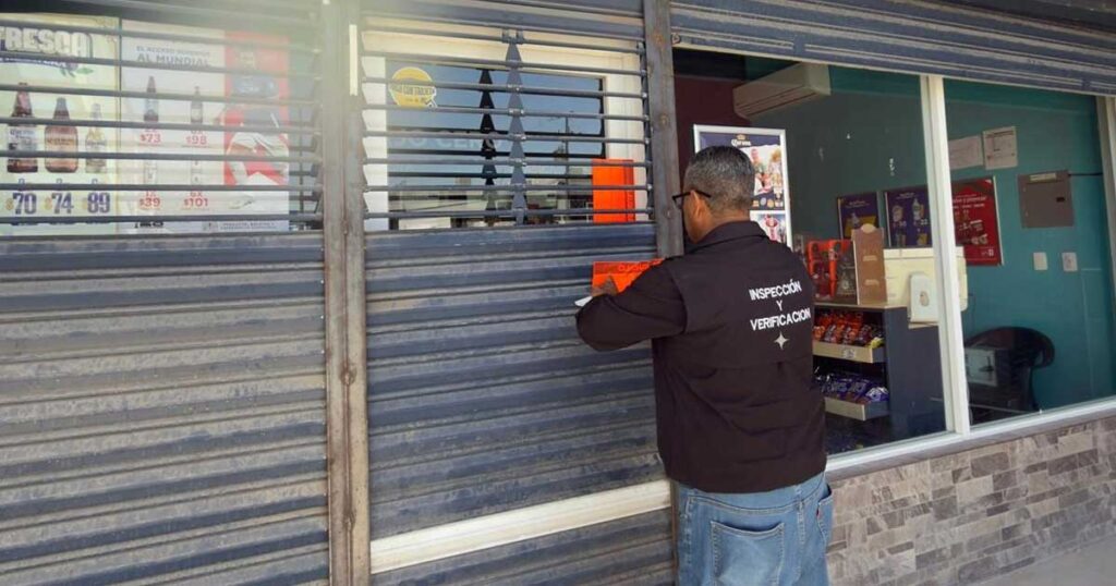 Inspector clausurando una tienda de bebidas alcohólicas.