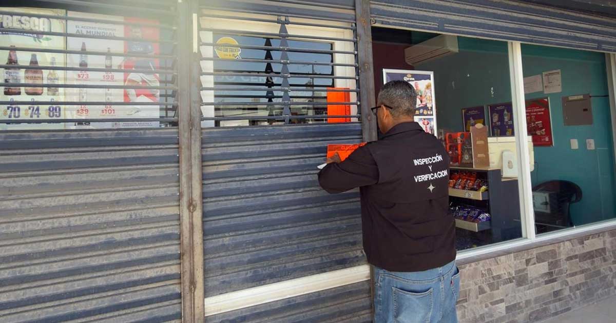 Inspector clausurando una tienda de bebidas alcohólicas.