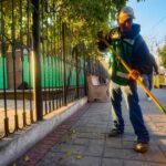 Trabajador de Ramos Arizpe barriendo una banqueta.